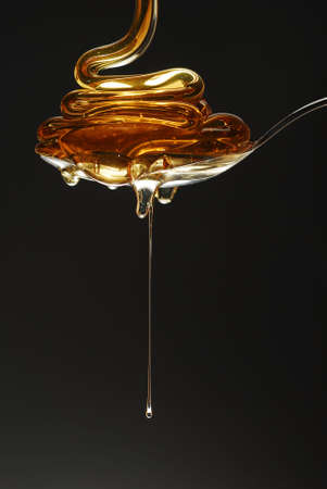 Honey with gold color on black stock photoの写真素材