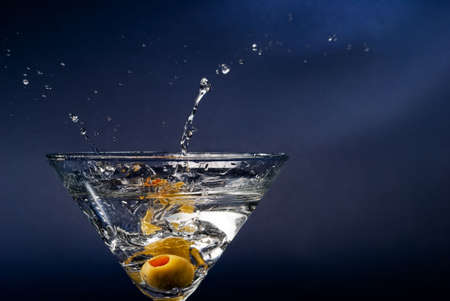 Splashing olive on cocktail glassの写真素材