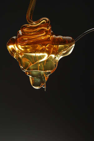 Golden honey spilling over the spoon stock photoの写真素材