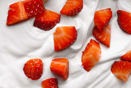 Chopped strawberry in a bowl of whipped creamの写真素材