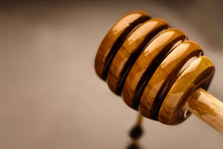 Bee nectar on a wooden honey dripperの写真素材