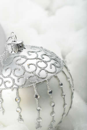 Silver christmas ornament in a white cotton snowの写真素材