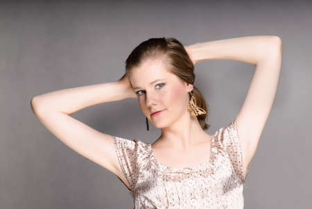 Girl portrait with arms up isolated on grayの写真素材