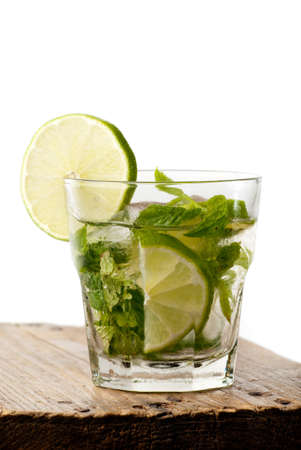 Vertical mojito glass with a slice of lime isolated on whiteの写真素材