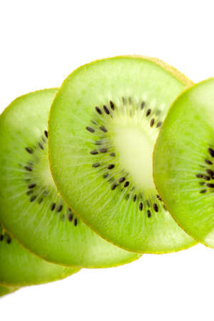 Slices green kiwi closeup side lighting on whiteの写真素材