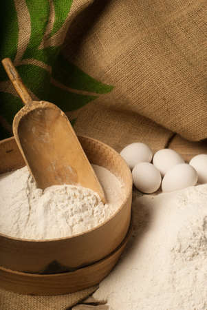 A bowl of flour and white eggs prepared for bakingの写真素材
