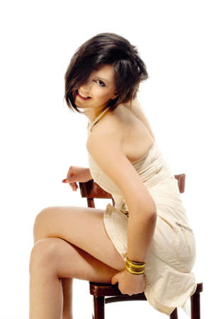 Smiling girl on a chair in sturio isolated on whiteの写真素材