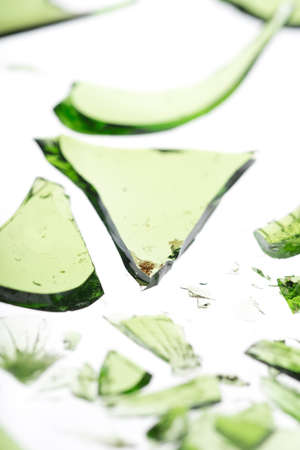 Smashed green bottle in pieces isolated on whiteの写真素材