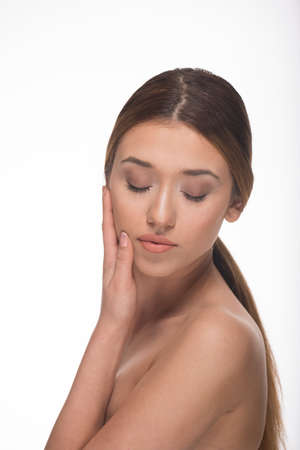 Portrait of a beautiful sensual woman isolated on white with closed eyesの写真素材