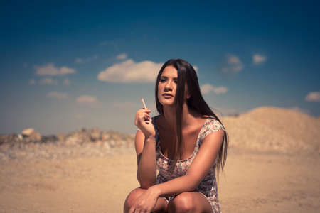 Lady in summer dress hitchhiking on a sunny dayの写真素材