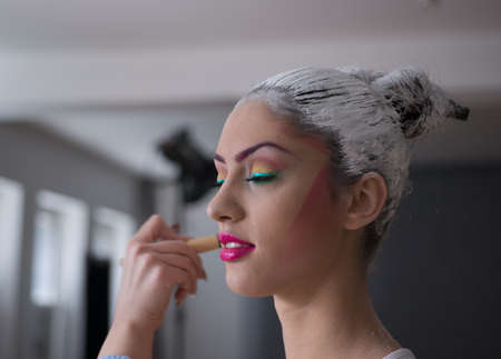 Model applying make up and preparing for photoshootの写真素材
