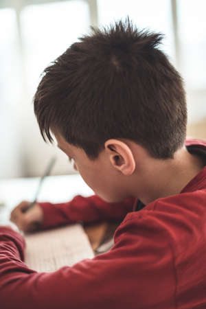 Boy doing homework mathematics at home