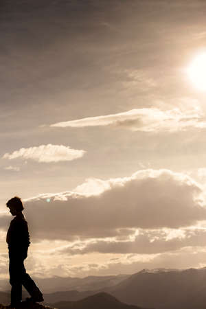 young boy walking on the edge of the mountain