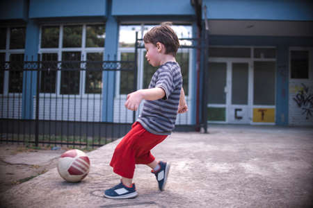 Small boy hitting the ball in the playgroundの写真素材