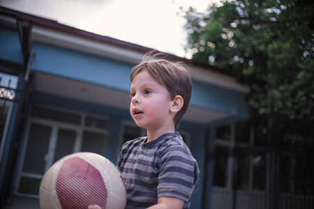 Young boy with a ball in the schoolyardの写真素材