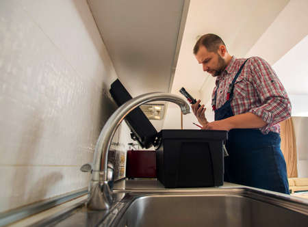 Plumber working in the kitchenの写真素材