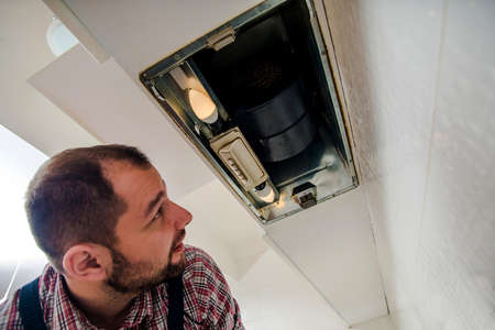 Electrician fixing the ventilationの写真素材