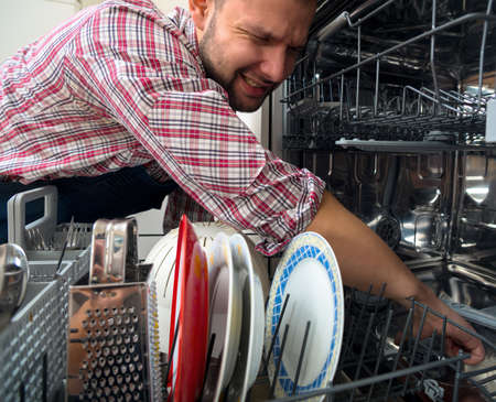 Electrician fixing the dishwasherの写真素材