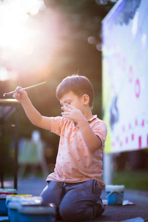 Toddler prepare to painting with watercolors into the parkの写真素材
