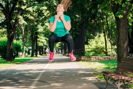 Fit girl stretchng before a run through the parkの写真素材