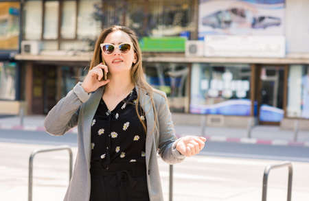 Happy woman speak and use smart phone outdoorの写真素材