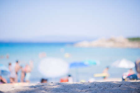 Blurred Background on a sunny day on the beach with clear blue sky and calm sea with people having funの写真素材