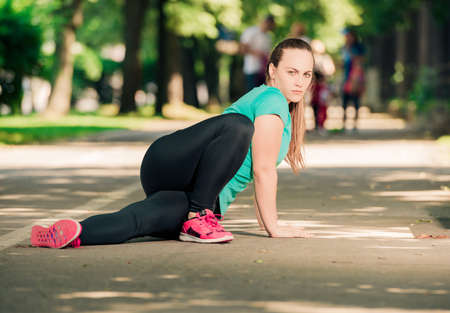 Picture of sporty young woman stretching on the running trackの写真素材