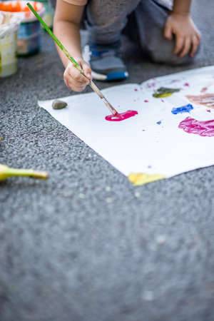 Toddler making atwork and painting with watercolors into the parkの写真素材