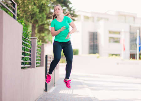 Sports girl stretching her body before a run through the cityの写真素材