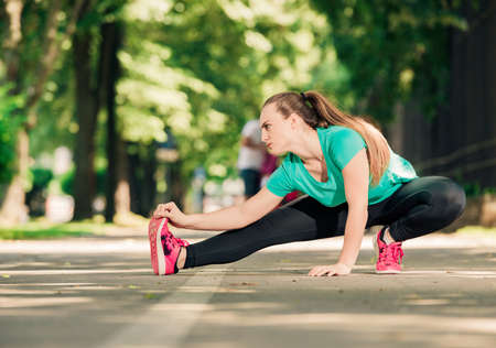 Picture of sporty young woman stretching outsideの写真素材