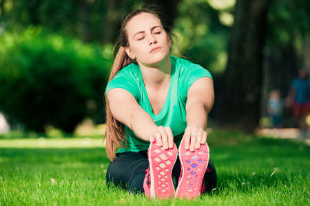 Gorgeous blonde woman doing stretching exercises while sittingの写真素材