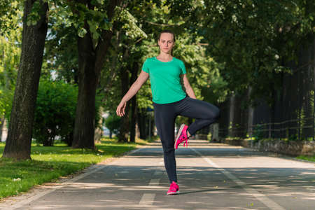 Young fitness woman runner stretching legs after run.の写真素材
