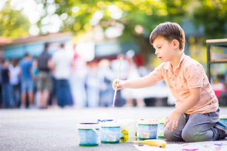 Portrait of adorable small kid  who playing with colours near the parkの写真素材