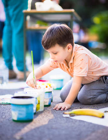 Portrait of adorable small kid  who playing with colours near the parkの写真素材