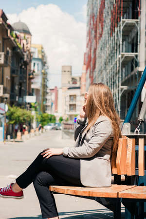 Young stylish business woman in a city street talk on cellphoneの写真素材