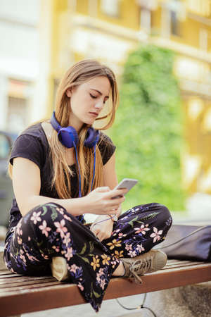 Beautiful woman model with headphones on the streetの写真素材
