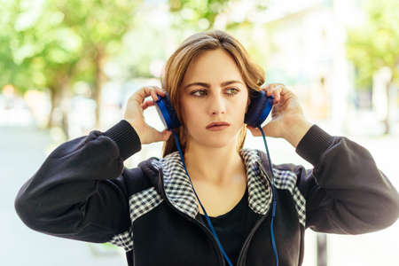 Teenager girl set up her headphones to listening musicの写真素材
