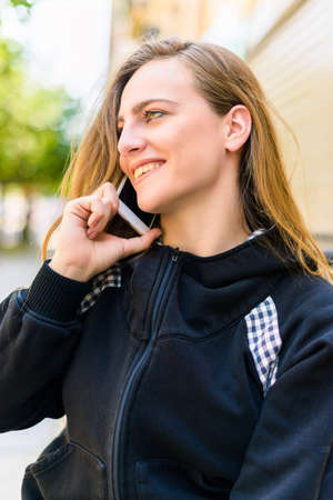 Closeup portrait of beautiful girl talking on the phoneの写真素材