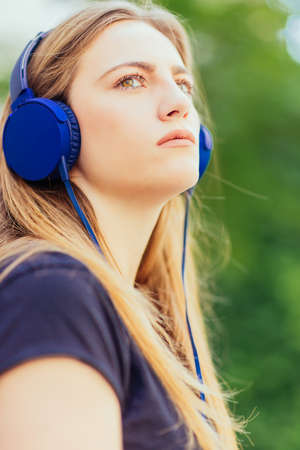 Urban young woman enjoying in the music on the parkの写真素材