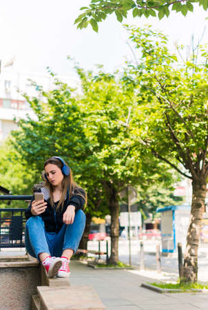 Portrait of carefree woman listening to music in a city centerの写真素材