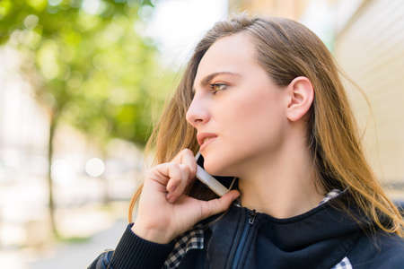 Portrait of young pretty woman talking with someone using cell phone. Outdoorsの写真素材