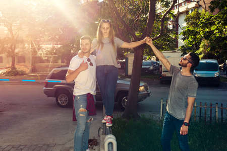 Group of friends walking along the street and having fun on sunny dayの写真素材