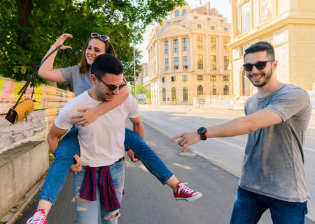 Group of friends having fun outdoors in sunny day in downtownの写真素材