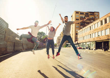 Happy group of young people walking together on sunny dayの写真素材