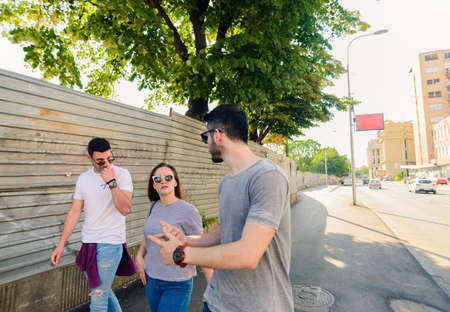 Happy young people walking down the city street and having funの写真素材