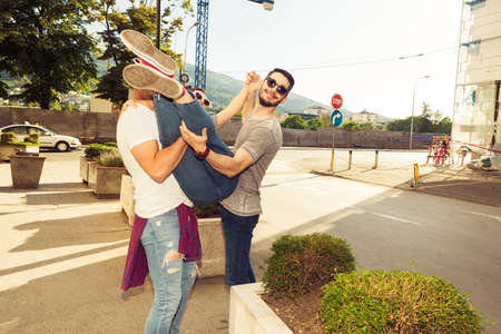 Young girl is hugging her friend while taking promenade in the cityの写真素材