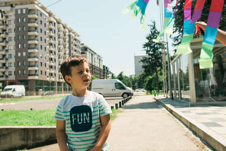 Young boy playing with kite in the school yard on a sunny dayの写真素材