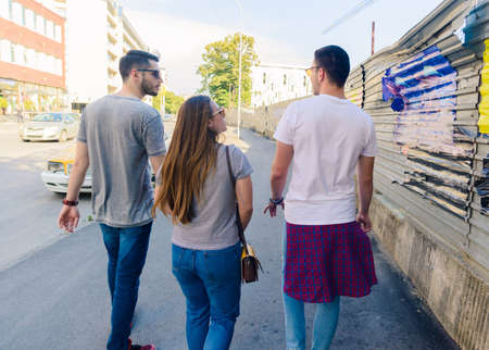 A group of friends walking on the sidewalk in an urban placeの写真素材