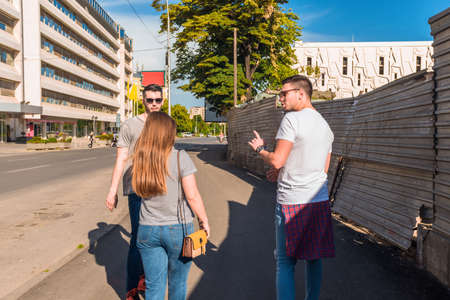 Happy group of young people walking together on sunny dayの写真素材