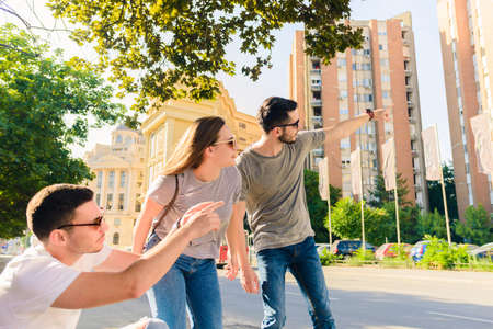 Group of friends having fun outdoors in sunny day in downtown